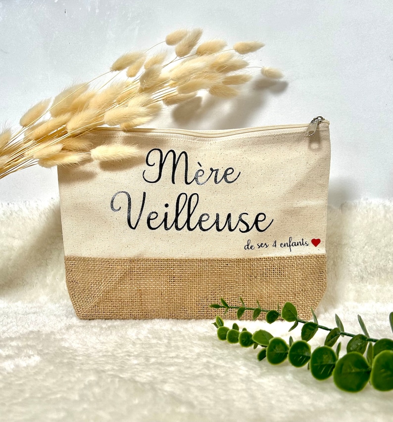 Op de afbeelding: Een witte canvas toilettas met een jute bodem. De tas heeft zwarte tekst die "M&egrave;re Veilleuse de ses 4 enfants" met een rood hartje luidt.