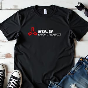 May include: Black t-shirt with a red and white logo that says "EG&G Special Projects".