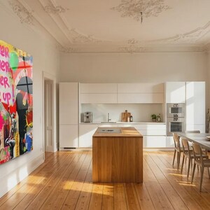 May include: A large, colorful wall art piece with graffiti-style artwork. The art features a child figure, butterflies, hearts, and the words "Follow Your Dreams" and "Never Give Up." The artwork is displayed in a modern, well-lit dining room.