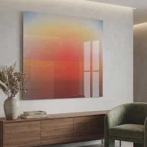 Peut inclure: Une grande peinture abstraite carrée avec un dégradé de couleurs, du bleu au jaune au rouge, est accrochée à un mur blanc. Un meuble en bois avec un vase de plantes séchées et des livres se trouve en dessous. Un fauteuil vert et un lampadaire complètent l'intérieur moderne.