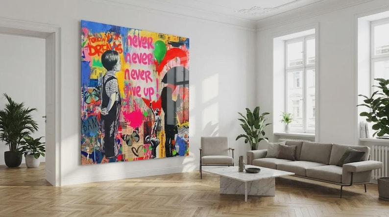 May include: A large, colorful artwork dominates a bright living room. The piece features graffiti-style art with the words "Follow Your Dreams" and "Never Give Up." A boy stands facing away, and a person holds a red umbrella.
