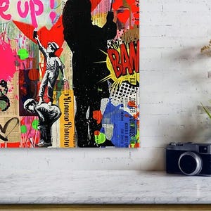 May include: A vibrant mixed-media artwork featuring graffiti-style elements. The piece includes a silhouetted figure, cartoon-style speech bubbles, and the word "Give up!" in pink. A butterfly and heart are also visible.