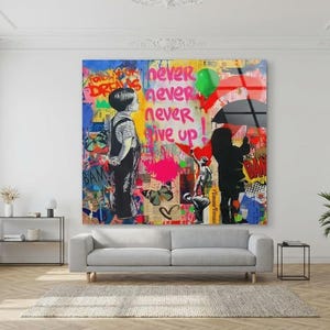 May include: A large, colorful wall art piece with graffiti-style art. The artwork features two children, one looking up and the other holding an umbrella. Text includes "Never Give Up" and "Follow Your Dreams."