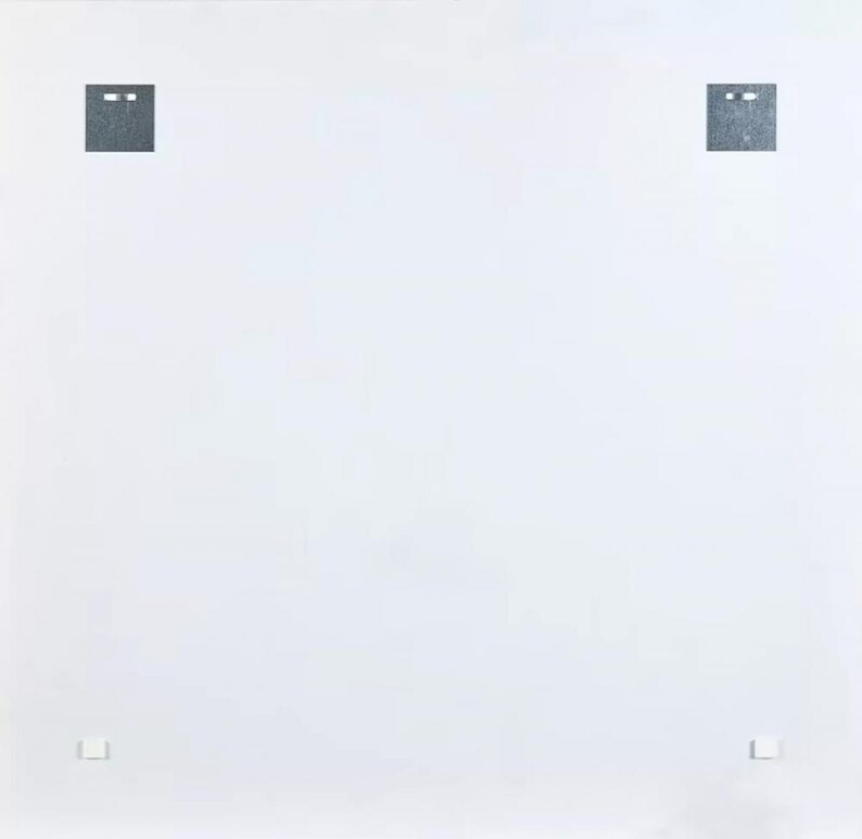 May include: A white background with two dark gray square shapes at the top and two smaller shapes at the bottom. The square shapes at the top have two small, horizontal, rectangular cutouts. The smaller shapes at the bottom are rectangular.