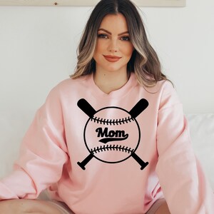 May include: A pink sweatshirt with a black baseball graphic and the word "Mom" in a vintage font.