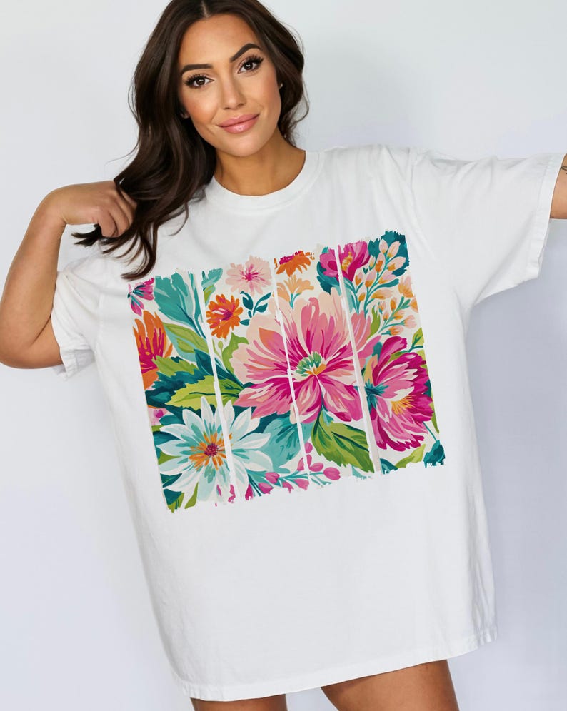 May include: White oversized t-shirt with a colorful floral print. The print features pink, red, orange, yellow, green, and blue flowers.
