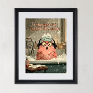 May include: Framed art print showing a pink, furry creature in a bubble bath, wearing a towel, headphones, and glasses. Text above reads, "I thought I'd locked the door!" The artwork has a humorous theme.