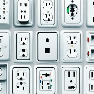 May include: A grid of various white electrical outlets, showcasing diverse designs and configurations. The outlets feature different prong arrangements and shapes, highlighting the variety of electrical standards. The image is a close-up, emphasizing the details of each outlet.