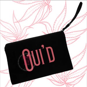 May include: Black clutch with a wrist strap. The word "Gui'd" is printed in pink on the front. The background features a pattern of pink cannabis leaves.