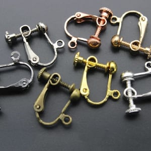 May include: Assortment of seven silver, gold, and rose gold earring clips. The clips are made of metal and have a screw-on closure. They are designed to be used with earrings that do not have a post.
