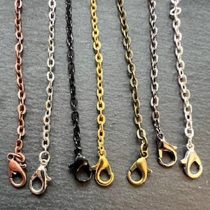 May include: Six different chain styles with lobster clasps. The chains are copper, silver, black, gold, bronze, and silver.