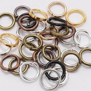 May include: A collection of assorted jump rings in silver, gold, and bronze colours. The jump rings are small and circular, perfect for jewellery making.