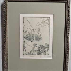 May include: Framed botanical print featuring a detailed etching of a plant with delicate flowers and leaves. The artwork is signed and titled "Oxalis" with a number 20/50. The frame is a decorative gold color with a light green mat.