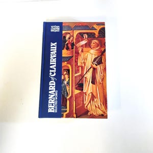 May include: A hardcover book titled "Bernard of Clairvaux: Selected Works" with a blue spine. The cover features a religious illustration with figures in robes and architectural details. The book is set against a white background.