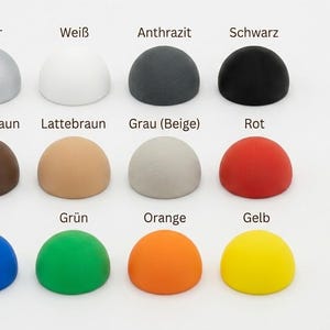 May include: A grid of twelve hemispherical objects arranged in three rows and four columns. The colors include silver, white, charcoal, black, dark brown, light brown, beige-gray, red, blue, green, orange, and yellow, each labeled with text.