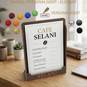 Könnte beinhalten: Ein brauner A5-Flyerständer mit dem Text "CAFE SELANI" und einem Menü. Der Ständer steht auf einer Holzoberfläche. Das Menü listet Kaffee- und Gebäckartikel auf. Der Ständer ist personalisiert und elegant.
