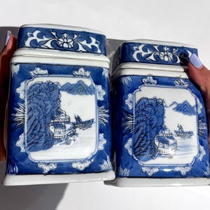 Pair of vintage Chinese blue and white porcelain tea caddies, 1950s–70s, scenic relief panels, floral sides, lidded, collectible export art
