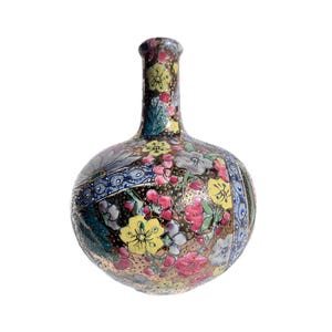 May include: A round vase with a narrow neck, decorated with a floral pattern. The design features pink, yellow, blue, and white flowers on a dark background. Gold detailing enhances the vase's elegant appearance.