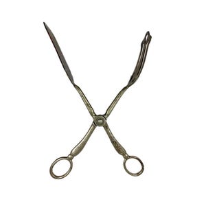 Puede incluir: Pinzas de servir plateadas con diseño de tijera. Un lado tiene una hoja plana, el otro un extremo en forma de tenedor. Los mangos tienen patrones grabados decorativos y orificios circulares para los dedos. De metal.