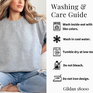 May include: Washing and care instructions for a grey sweatshirt. Wash inside-out with like colors, wash in cool water, tumble dry at low temperature, do not bleach, and do not iron the design. Gildan 18000.
