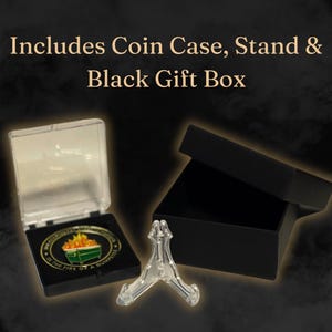 May include: A clear plastic coin case with a black lid, a clear plastic stand, and a black gift box. The coin case contains a gold-colored coin with a green trash can and flames on it. The coin has the text "IN THE FIRE OF A QUIAPSTER" around the edge.