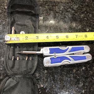 May include: A blue and silver multi-tool with a black carrying case. The multi-tool has a screwdriver bit holder and a tape measure that reads "25ft" and "STANLEY".