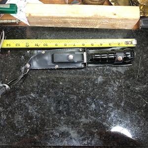 Coltello da sopravvivenza con custodia e scomparto per fiammiferi e rullante