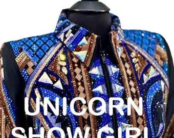 May include: A black jacket featuring intricate blue and bronze geometric patterns, embellished with numerous reflective crystals and studs. The garment has a collared neckline and a central zipper closure. The text UNICORN SHOW GIRL is visible.
