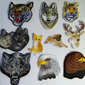 May include: A selection of embroidered animal patches, featuring a tiger, wolf, cat, pug, deer, and eagle. The patches showcase detailed stitching in various colours, highlighting the animals' faces. Ideal for customising clothing or craft projects.