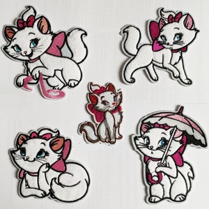 Può includere: Cinque toppe ricamate da stirare con un gatto bianco con accenti rosa. Il gatto è raffigurato in varie pose, tra cui seduto, in piedi e con un ombrello.