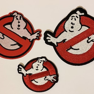 May include: Three embroidered Ghostbusters logo patches. Each patch features a red circle with a red slash through a white ghost figure. The patches are of different sizes and have black borders.