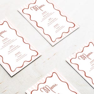 Może przedstawiać: Kilka kart menu z różowo-białym paskowanym tłem i brązową falistą obwódką. Słowo "Menu" jest napisane kursywą u góry. Menu zawiera przystawki, dania główne i desery.