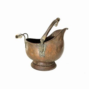 Peut inclure: Un seau à charbon en cuivre avec une patine vieillie, doté d'une grande anse arquée et d'une poignée arrière plus petite, toutes deux avec des prises cylindriques blanches. Le corps présente une applique en laiton en forme de tête de lion.