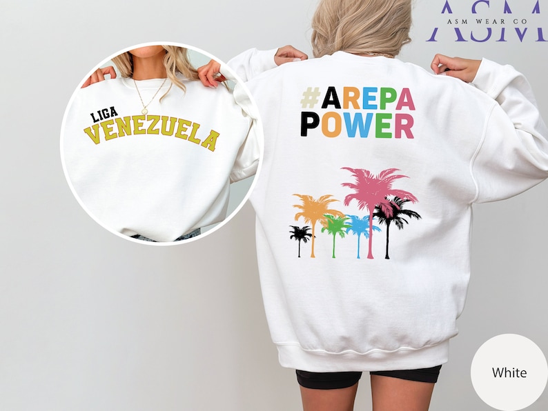 May include: White sweatshirt with the text "LIGA VENEZUELA" on the front and "#AREPA POWER" with a row of colorful palm trees on the back.