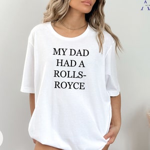 May include: White t-shirt with the text "My Dad Had A Rolls-Royce" printed on the front.