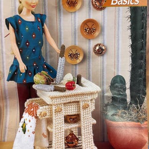 May include: A doll wearing a blue patterned dress stands next to a miniature, cream-colored butcher block cart with wooden wheels. The cart has a towel hanging from it and a red pepper on top. The image includes the text "Butcher Block Basics".