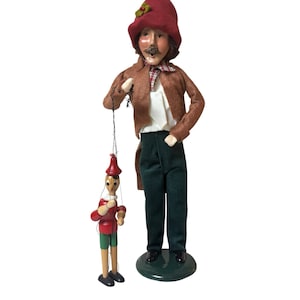 May include: A white ceramic mug with a black handle and the text "But First, Coffee" in a bold, black font. The mug is sitting on a wooden surface. The mug is 4 inches tall.