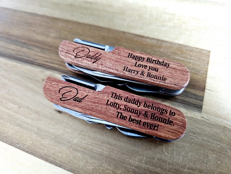 May include: Two wooden multi-tools with stainless steel tools. One is engraved with "Daddy" and "Happy Birthday Love you Harry & Ronnie." The other says "Dad" and "This daddy belongs to Lotty, Sonny & Bonnie. The best ever!"
