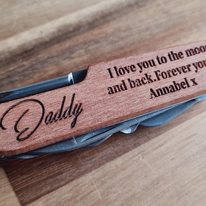 May include: A wooden multi-tool with a stainless steel blade and tools. The tool is engraved with the word "Daddy" and the message "I love you to the moon and back. Forever yours, Annabel x."