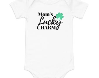 May include: White baby onesie with black text that reads "Mom's Lucky Charm" and a green four-leaf clover graphic.