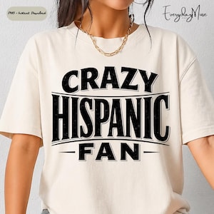May include: A cream-coloured t-shirt featuring the text "CRAZY HISPANIC FAN" in bold black lettering. The design is centrally placed, with the words stacked and underlined. The t-shirt has short sleeves and a relaxed fit.