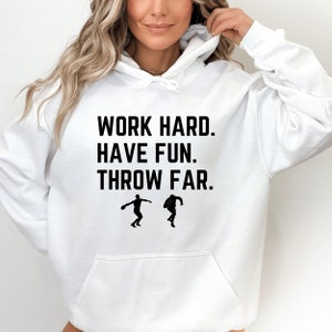 May include: White hoodie with the text "WORK HARD. HAVE FUN. THROW FAR." and two silhouettes of people throwing a discus.