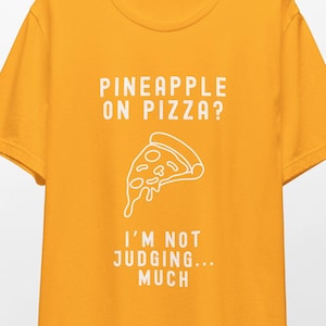 May include: A yellow t-shirt with the text "Pineapple on pizza? I'm not judging... much" and a white outline of a pizza slice.