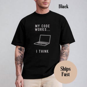 Peut inclure: T-shirt noir avec un graphique blanc d'un ordinateur portable et le texte "My code works... I think."