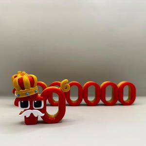 May include: A red number 9 with a crown and mustache, followed by the numbers 60000 in red. The numbers have a yellow outline. The number 9 has eyes and a mustache.