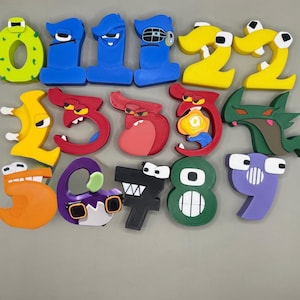 May include: A collection of colorful, three-dimensional number figures zero through nine, each designed with unique facial features, eyes, and expressions. The set includes various shapes and vibrant colors like lime green, blue, yellow, red, orange, purple, black, and dark green.