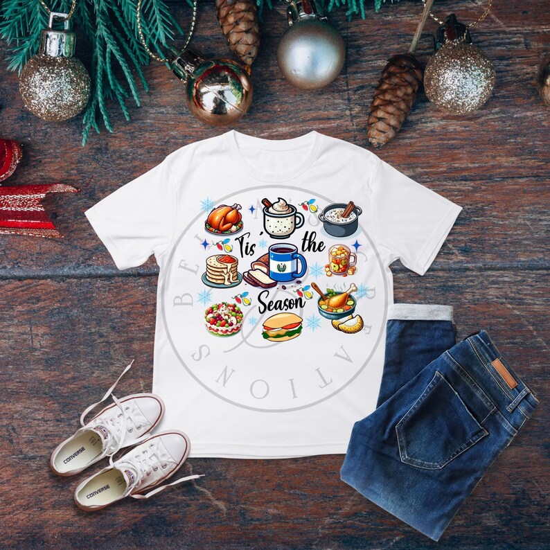 May include: White t-shirt with a festive design featuring various holiday foods and the text "Tis the Season".