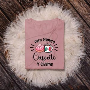 May include: Pink t-shirt with a graphic design featuring a pastry, a coffee cup, and the text "Pero Primero Cafecito Y Chisme".