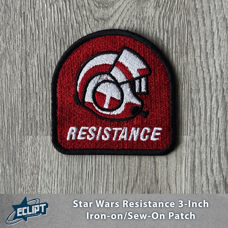 May include: A red and black embroidered patch featuring a stylized helmet design with the word "RESISTANCE" in white. The patch is approximately 3 inches in size and is an iron-on or sew-on patch.