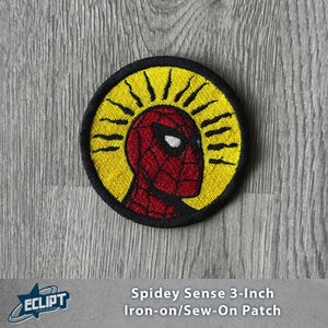 May include: A round, embroidered patch featuring Spider-Man's head in red and black, set against a yellow background with black rays. The patch is 3 inches in diameter and has a black border. Text at the bottom reads "Spidey Sense 3-Inch Iron-on/Sew-On Patch."